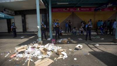 Comerciantes y miembros de la Policía Nacional fueron registrados este viernes al vigilar varios negocios después de un intento de saqueo en el Mercado Oriental, en Managua (Nicaragua). EFE