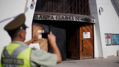 Un policía inspecciona los daños causado a uno de los templos atacados en Santiago, la capital.