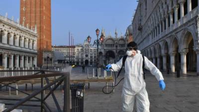 Empleados municipales desinfectan las plazas turísticas de Venecia./AFP.