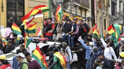 El líder opositor Luis Fernando Camacho ondea una bandera nacional boliviana en La Paz después de conocer que Evo Morales había renunciado a la presidencia. AFP