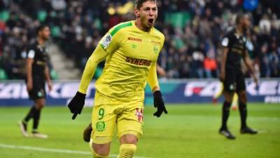 A person stands in front of a portrait of Nantes' Argentinian forward Emilianio Sala, who died one year ago in a plane crash, ahead of the French L1 football match between FC Nantes and Bordeaux in front of the La Beaujoire stadium in Nantes, western France, on January 26, 2020. - The 28-year-old striker was killed when the small plane taking him to join the then Premier League club Cardiff after being bought from Nantes crashed off the Channel island of Guernsey. (Photo by Sebastien SALOM-GOMIS / AFP)