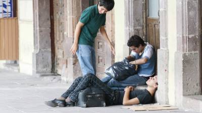 Tres jóvenes pasan el rato en una acera de la capital de México, país donde se reportan las cifras más elevadas.