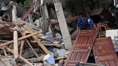 Un hombre trata de rescatar algunos materiales de un hotel destruido en el balneario de Pedernales, donde se produjo el epicentro del terremoto.