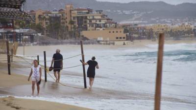 Un grupo de personas camina por una playa frente al Cabo San Lucas el estado mexicano de Baja California Sur. EFE