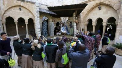 Peregrinos cristianos hacen fotografías a un belén en la Basílica de la Natividad.