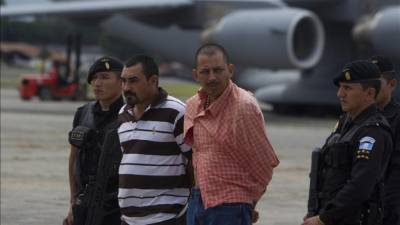 Wilmar Anavisca, alias 'El Chino' (2i), y Antonio Pompa, alias 'Toño' (c), son escoltados por autoridades guatemaltecas, en Ciudad de Guatemala, donde serán recluidos en una prisión de máxima seguridad. EFE