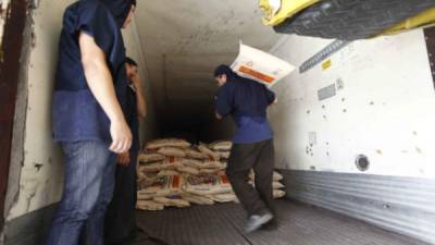 Trabajadores cargan de sacos de azúcar un camión en Villanueva, Cortés.