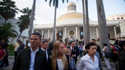 Diputados venezolanos caminan por los patios en el exterior de las instalaciones de la Asamblea.