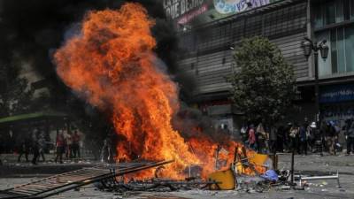 Vista de una explosión en Santiago en el sexto día consecutivo de violencia callejera que estalló sobre una subida ahora suspendida en los precios de las entradas del metro, el 23 de octubre de 2019. - Un niño de cuatro años fue asesinado durante la última ronda de protestas. contra la desigualdad económica en Chile, elevando el número de muertos de cinco días de disturbios sociales a 18 cuando los sindicatos lanzaron una huelga general el miércoles. (Foto por JAVIER TORRES / AFP)