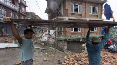 Varios nepalíes participan en la labores de reconstrucción de las viviendas destruidas por los sucesivos terremotos que han asolado Nepal. EFE
