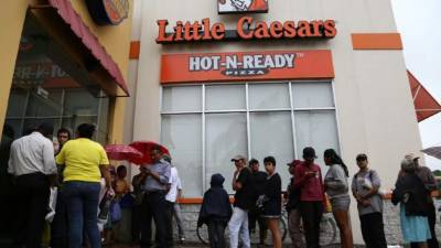 Antes que se abrieran los restaurantes los sampedranos ya hacían filas para reclamar sus piezas de pollo.