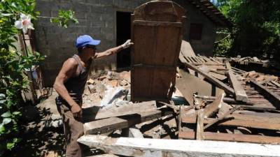 Un hombre busca madera cerca de una casa dañada por el sismo en Chinandega, Nicaragua. Foto: AFP