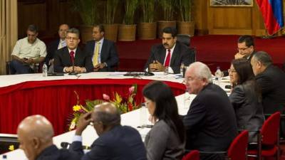 El presidente venezolano, Nicolás Maduro (c), y su equipo de Gobierno se reúnen con los miembros de la Mesa de Unidad Nacional (MUD) y representantes del Nuncio Eclesiástico venezolano y cancilleres de Unasur hoy, jueves 10 de abril de 2014, en el Palacio de Miraflores en Caracas (Venezuela). El Gobierno y la oposición comenzaron hoy el diálogo para tratar de encontrar salidas a la crisis política en el país en presencia de una representación de tres cancilleres de la Unión de Naciones Suramericanas (Unasur) y del nuncio en Caracas, Aldo Giordano. EFE