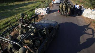 Militares inspeccionan a miembros de autodefensas en el poblado de Las Huertas, Michoacán (México), quienes custodiaban hoy, domingo 19 de enero de 2014, los caminos para evitar la incursión de los Caballeros Templarios, a espera de la llegada de las fuerzas federales al lugar, donde deberán tomar el control. EFE