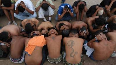 ESA03. APOPA (EL SALVADOR), 09/03/2013.- Pandilleros salvadoreños participan en la entrega de unas 267 armas de fuego a las autoridades hoy, sábado 9 de marzo de 2013, durante un acto donde el municipio de Apopa, al norte de San Salvador, fue declarado como el sexto 'municipio santuario' o libre de violencia de maras como producto de la 'tregua al cumplirse el primer aniversario de la 'tregua' que ha disminuido los homicidios en el país. La 'tregua' entre las principales pandillas de El Salvador cumplió hoy un año con una disminución de alrededor del 50% de los homicidios, aunque persisten dudas y señalamientos sobre su transparencia y sostenibilidad. EFE/Roberto Escobar