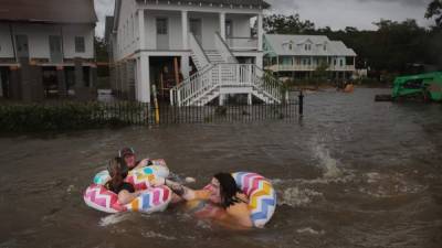 La gente flota en Lakeshore Drive, que está cubierta por el agua del lago Pontchartrain después de que el área se inundó tras el huracán Barry