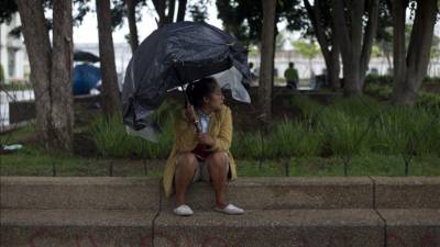 Una mujer con una sombrilla de bolsas plásticas se protege de la lluvia en Ciudad de Guatemala. EFE/Archivo Una mujer con una sombrilla de bolsas plásticas se protege de la lluvia en Ciudad de Guatemala. EFE/Archivo