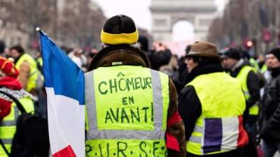 Un manifestante lleva un chaleco con el lema 'desempleados adelante' durante la marcha de protesta de 'Chalecos Amarillos' en el bulevar de los Campos Elíseos, en París, este sábado 5 de diciembre. EFE