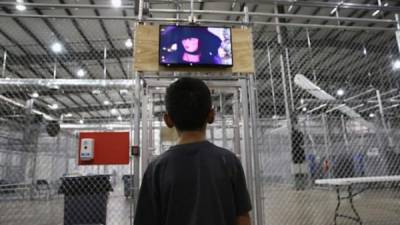 Un niño inmigrante de origen hondureño viendo una película en un centro de detención.