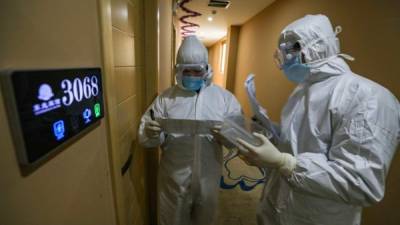 This photo taken on February 3, 2020 shows medical staff members on their rounds at a quarantine zone in Wuhan, the epicentre of the new coronavirus outbreak, in China's central Hubei province. - The number of total infections in China's coronavirus outbreak has passed 20,400 nationwide with 3,235 new cases confirmed, the National Health Commission said on February 4. (Photo by STR / AFP) / China OUT