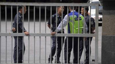 La policía de Malasia custodia la entrada de las instalaciones de Medicina Forense en Kuala Lumpur.