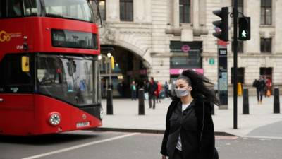 Una mujer camina usando una mascarilla para prevenir el Covid-19 en Londres. Foto: AFP