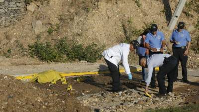 Agentes de la DPI revisan la escena del crimen.