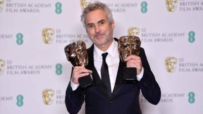Mexican director Alfonso Cuaron poses with the awards for a Director and for Best Film for 'Roma' at the BAFTA British Academy Film Awards at the Royal Albert Hall in London on February 10, 2019 (Photo by Ben STANSALL / AFP)