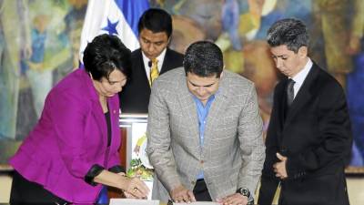 La canciller Mireya Agüero, el presidente Juan Orlando Hernández y el director del RNP, Miguel Villeda, en la firma de convenio.