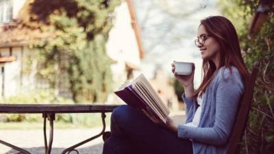 Woman drinking tea and reading a book