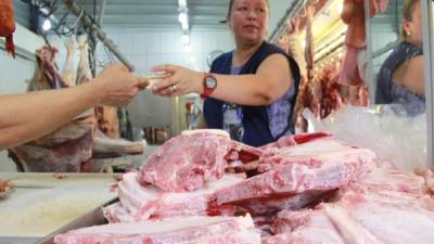 Un cliente paga la libra de carne de cerdo que compró en un puesto del mercado Dandy. Foto: Cristina Santos