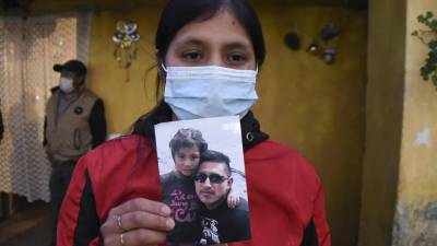 Lucrecia Alba Xaminez, 28, muestra una foto de su esposo Celso Escu Pacheco, uno de los pocos sobrevivientes al fatal accidente del pasado viernes.