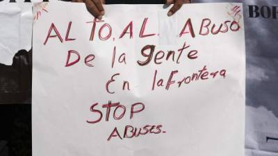 Miembros de una delegación de residentes de la zona fronteriza sostienen un cartel. Foto: AFP