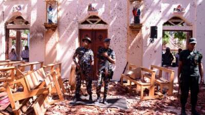 Sri Lankan soldiers look on inside the St Sebastian's Church at Katuwapitiya in Negombo on April 21, 2019, following a bomb blast during the Easter service that killed tens of people. - A series of eight devastating bomb blasts ripped through high-end hotels and churches holding Easter services in Sri Lanka on April 21, killing nearly 160 people, including dozens of foreigners. (Photo by STR / AFP)