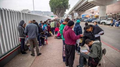 Un grupo de migrantes venezolanos, guatemaltecos, hondureños y mexicanos esperan para iniciar la solicitud de visa humanitaria afuera de la oficina fronteriza estadounidense de El Chaparral, en la frontera de la ciudad de Tijuana. EFE