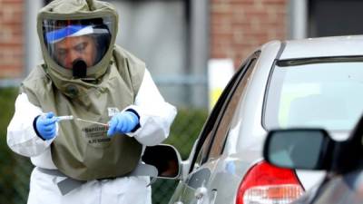 SOMERVILLE, MASSACHUSETTS - APRIL 28: A medical professional administers a coronavirus test at a drive-thru testing site at Cambridge Health Alliance Somerville Hospital on April 28, 2020 in Somerville, Massachusetts. The city of Somerville is offering free testing to any resident who wants it, and requiring residents to wear masks in public spaces in order to combat the spread of coronavirus (COVID-19). Maddie Meyer/Getty Images/AFP== FOR NEWSPAPERS, INTERNET, TELCOS & TELEVISION USE ONLY ==