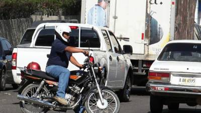 Conductor de moto circula en una calle del centro.