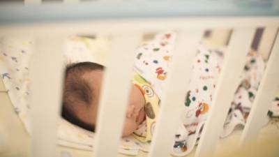 Un bebé recién nacido duerme en una cuna. EFE/Archivo