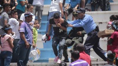 Momentos en que agentes de la Policía Nacional y de la Policía Militar intervienen para controlar a varios jóvenes que protagonizaban un relajo en las graderías populares del Estadio Nacional.