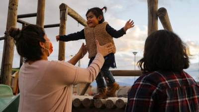 María Cecilia Jara (izquierda), 34, Marcela Paz Osorio (derecha), 34, y su hija María Paz Jara Osorio, 1, son vistas en una plaza de Paine, el 25 de julio de 2021. - El 21 de julio, el Senado de Chile. aprobó el matrimonio igualitario, y ahora aguarda un rápido trámite en la Cámara de Diputados para convertirse en ley. (Foto de JAVIER TORRES / AFP)