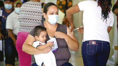 inmunización. Una madre recibe su vacuna en la terminal de buses de San Pedro Sula.
