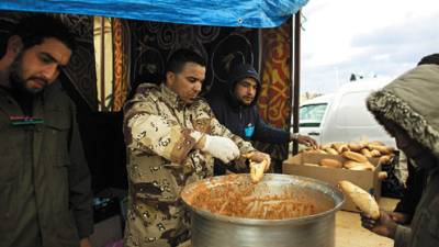 Libyans give out food during a protest in the eastern city of Benghazi, Libya, Saturday, Feb. 26, 2011. (AP Photo/Tara Todras-Whitehill