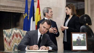 La Reina Letizia conversa con el embajador de Francia en España, Yves Saint-Geours, en la residencia del embajador en Madrid, mientras el Rey Felipe VI firma en el libro de condolencias instalado en el vestíbulo de esta representación diplomática por los atentados terroristas de ayer en París. EFE