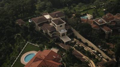 A photographer takes a picture of a tile decoration depicting Pope John Paul II in the chapel at one of the properties confiscated from Salvadorean former president (2004-2009), Elias Antonio Saca, in San Salvador, on August 10, 2018.The Attorney General's Office of Salvador announced on August 10, 2019 the confiscation of Saca's several properties and assets. The former president pleaded guilty in court in July for crimes of embezzlement and money laundering during his government in exchange for an abbreviated trial and the reduce of his prison sentence. Saca and six ex-administration officials are on trial for embezzling $301 million in public funds. / AFP PHOTO / Oscar Rivera