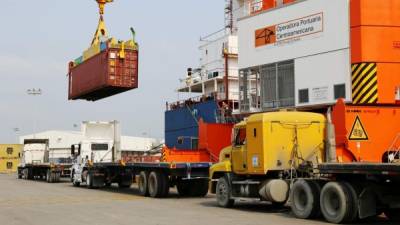 Una grúa se apresta a colocar la carga sobre un camión en una de las terminales de la OPC en Puerto Cortés.