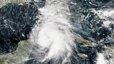 HAB101. LA HABANA (CUBA), 08/10/2018.- Personas se cubren de la lluvia hoy, lunes 8 de octubre del 2018, antes de la llegada de la tormenta tropical Michael, en La Habana (Cuba). Las autoridades cubanas decretaron la primera fase del protocolo ante huracanes en cinco provincias del oeste de la isla, incluida La Habana, ante la cercanía de la tormenta tropical Michael, que previsiblemente se convertirá hoy en huracán y dejará fuertes lluvias, viento e inundaciones costeras. EFE/Yander Zamora