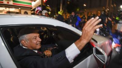 El recién electo presidente de México, Andrés Manuel López Obrador, saluda a sus seguidores desde un automóvil al llegar al hotel donde dará una conferencia de prensa.