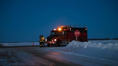 Un vehículo de emergencia yace en la carretera cerca del lugar del accidente.