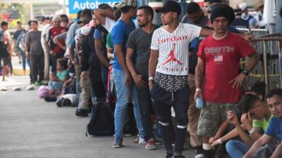 Migrantes centroamericanos de la segunda caravana esperan a que los funcionarios de inmigración les entreguen su tarjeta de visitante para continuar su viaje en Ciudad Hidalgo. Foto: AFP