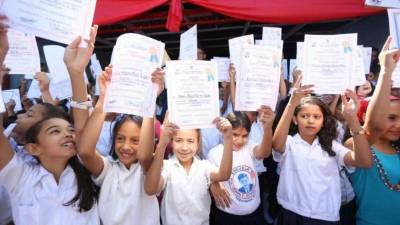 Estudiantes de la Escuela John F. Kennedy muestran sus certificados.